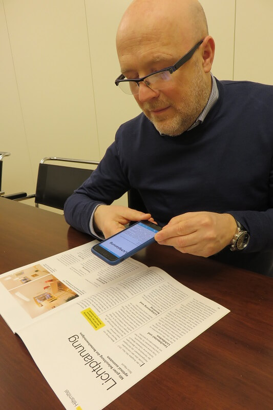 Fotografierte Dokumente werden vorgelesen – derzeit noch mit englischer Sprachausgabe. Mitarbeiter Daniele Marano fotografiert mit seinem Smartphone das Magazin Sichtweisen.
