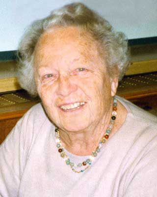 Hedwig Immervoll Eine ältere Dame mit Dauerwelle und bunter Kette lächelt fröhlich in die Kamera