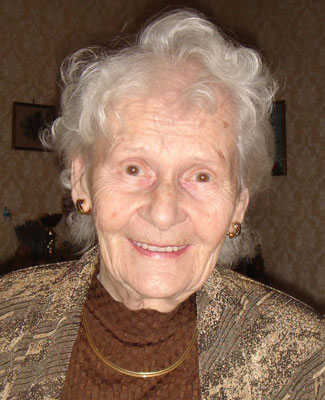 Leopoldine "Susi" Gruntorad Eine ältere Dame mit Dauerwelle lächelt fröhlich in die Kamera