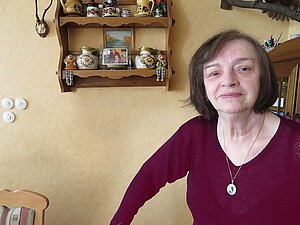 Wir haben die blinde Frau K. in ihrer Wohnung besucht. Frau K. in ihrem Wohnzimmer vor einem Regal