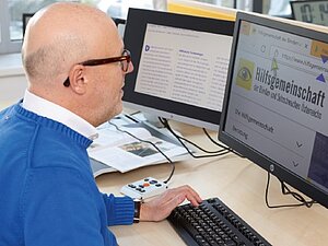 Ein Mann arbeitet an einem für sehbehinderte Menschen ausgestattetem Arbeitsplatz (Symbolbild). Ein Mann arbeitet an einem für sehbehinderte Menschen ausgestattetem Arbeitsplatz.