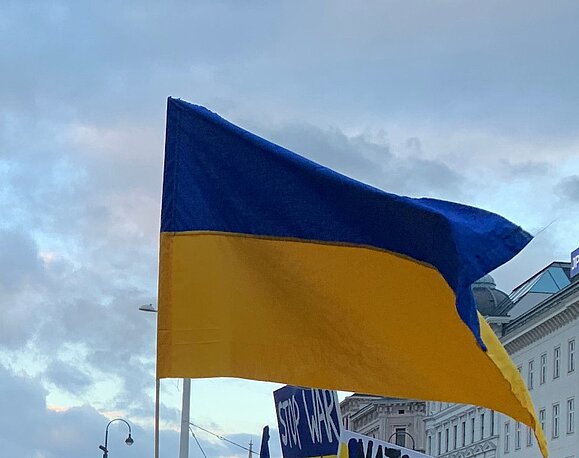 Unterstützung für geflüchtete Menschen muss barrierefrei sein. Ukraineflagge vor blauem Himmel