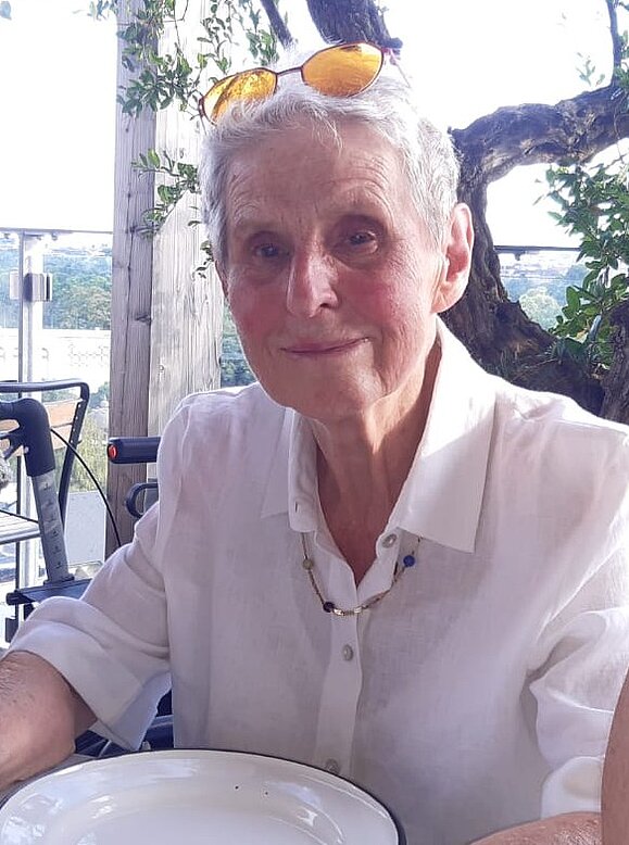 Gerda Luise Hoschek Eine Frau mit grauen Haaren lächelt in die Kamera