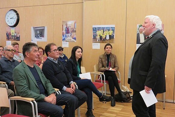 Vorstandsvorsitzender Dr. Elmar Fürst eröffnete den Mobilitätstag im Beratungszentrum Vorstandsvorsitzender Dr. Elmar Fürst steht vor dem sitzenden Publikum und spricht in ein Mikrofon
