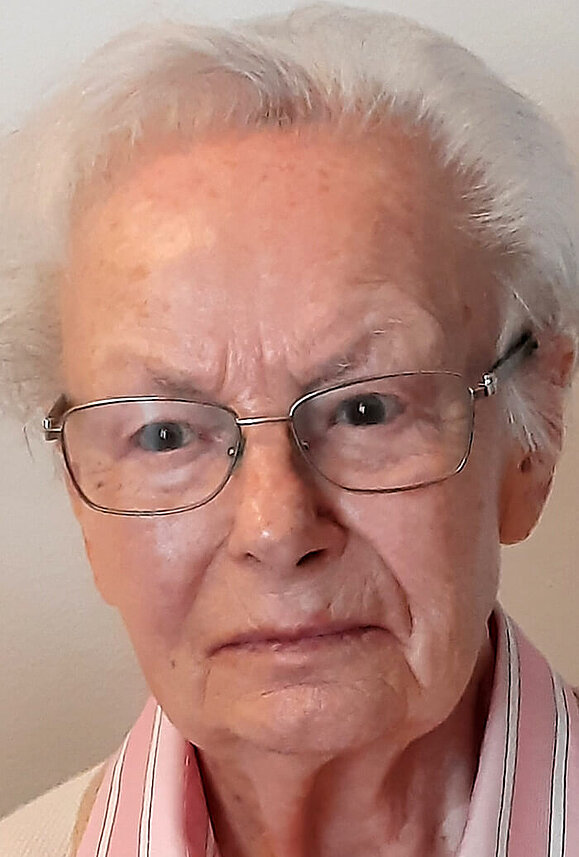 Hedwig Schweitzer liebte das Meer vor Hellas Stränden ebenso wie kalifornische Wüstenformationen. Selbst seheingeschränkt war sie zeitlebens eine freigiebige Frau. Ältere Dame mit weißen, kurzen Haaren, Brille und hellrosa Hemd.