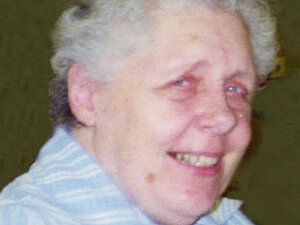 Marianne Urbanek Portrait einer älteren Dame mit Dauerwelle die freundlich lächelnd seitlich in die Kamera blickt