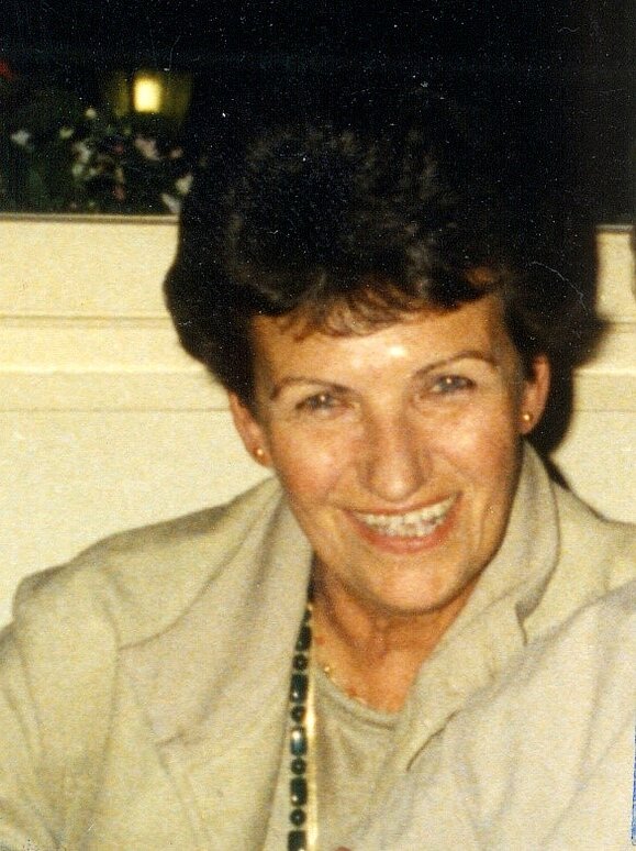 Edith Trost Eine Dame mittleren Alters mit dunkler Dauerwelle lacht herzlich in die Kamera