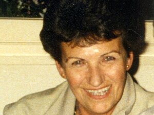 Edith Trost Eine Dame mittleren Alters mit dunkler Dauerwelle lacht herzlich in die Kamera