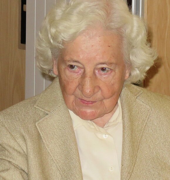 Josefine Andress Dame älteren Alters mit weißen lockigen Haaren und hellem Blazer