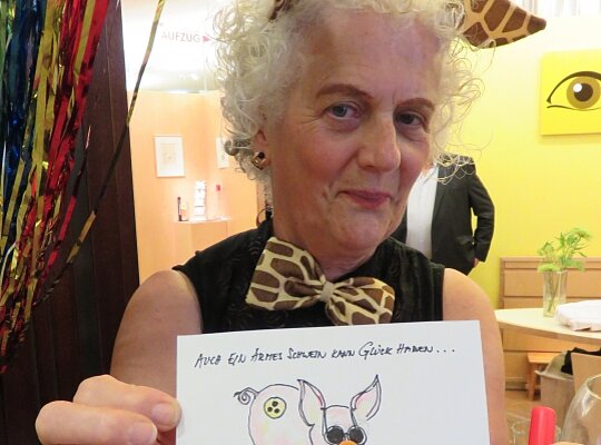 Danke-Fest der Hilfsgemeinschaft zum Thema „So ein Zirkus!“ Eine Frau hält beim Danke-Fest der Hilfsgemeinschaft ein Bild in die Kamera.