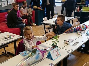 Kinder sind mit Schultüten in einer Klasse und haben ihren ersten Schultag