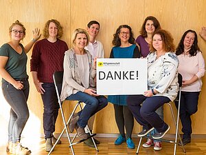 Das Team der Hilfsgemeinschaft sagt Danke! Copyright: Franz Pfluegl 7 Frauen halten das Schild "Danke" in die Kamera.