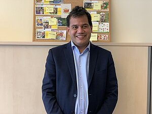 Marco Blumenreich ist seit seiner Geburt praktisch blind. Unser Mitglied Marco Blumenreich steht vor einer Pinnwand der Hilfsgemeinschaft.