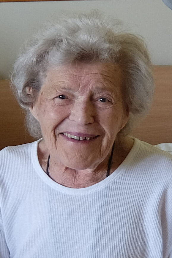 Maria Neumann Eine ältere Dame mit weißer Dauerwelle lächelt freundlich in die Kamera