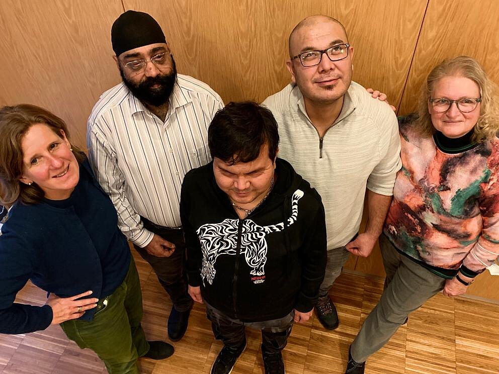 Deutsch_Konversation_Hilfsgemeinschaft Vogelperspektive: drei Männer und zwei Frauen lachen nach oben in die Kamera