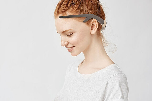 „Rey“ wird wie ein stylisches Headset getragen, Copyright: Clara Fessler Junge Frau trägt auf ihrem Kopf Rey, ein Headset für sehbeeinträchtigte Menschen