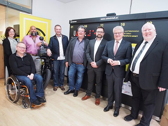 Mit großer Freude wurde die Paketbox eröffnet Gruppenfoto mit versammelten Personen vor Paketbox lächeln in die Kamera