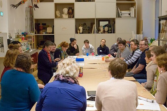 Die Workshops waren für alle Teilnehmenden eine Bereicherung, Copyright: Sabine Gruber Blick in eine Workshop-Gruppe mit zahlreichen Teilnehmenden an einem großen Tisch