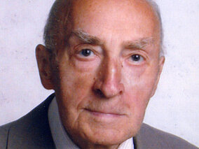 Walter Gottsbachner Ein älterer Herr mit Anzug und gelber Krawatte lächelt leicht in die Kamera.