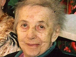 Maria Göschl Eine ältere Dame mit bunter Weste lächelt in die Kamera.