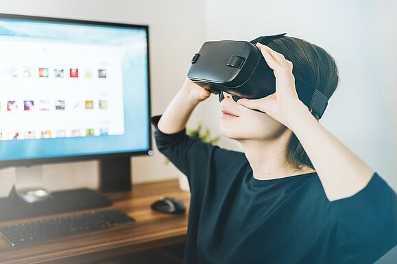 Barrierefreies Gaming ist hochgefragt. Foto: Unsplash. Junger Bub mit VR-Brille sitzt am Schreibtisch mit PC schaut nach oben