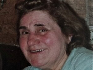 Anna Starycha war ihr Leben lang für andere da, das setzt sie auch jetzt mit ihrer Testamentsspende fort. ältere Frau mit blauem Pullover, braunen schulterlangen Haaren und roten Backen lächelt in die Kamera