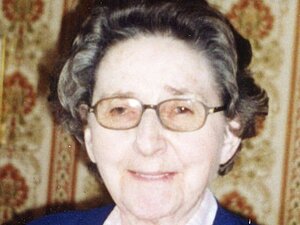 Irmentraute Brokesch Eine ältere Dame mit Brille lächelt verschmitzt in die Kamera