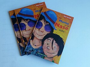 Mehrere Ausgaben des Buches "Wie Mama mit der Nase sieht" liegen auf einem Tisch