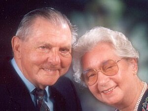 Gertrude und Ludwig Kucera Ein älteres Ehepaar sitzt einander zugeneigt und lächelt fröhlich in die Kamera