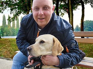 Alexander S. und sein Blindenführhund Flint sind ein tolles Team Alexander S. kuschelt mit seinem Blindenführhund Flint.