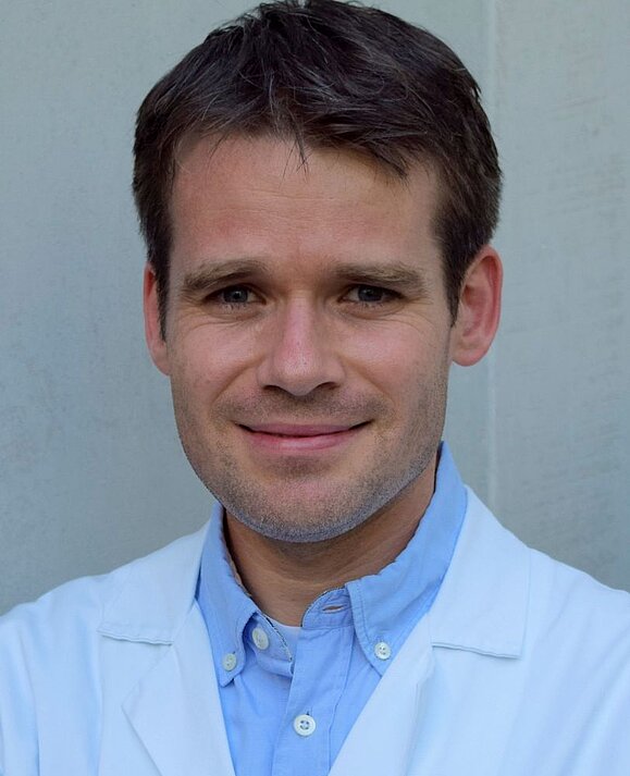 Assoz. Prof. Priv.-Doz. Dr. Markus Ritter, Foto: privat Mann mit weißem Labormantel lächelt in die Kamera