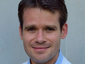 Assoz. Prof. Priv.-Doz. Dr. Markus Ritter, Foto: privat Mann mit weißem Labormantel lächelt in die Kamera