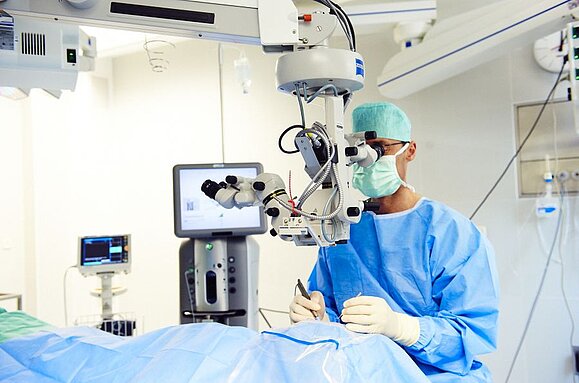 Augen-Op, Copyright: Barmherzige Brüder Wien Ein Arzt operiert eine Person, die am Op-Tisch liegt, am Auge